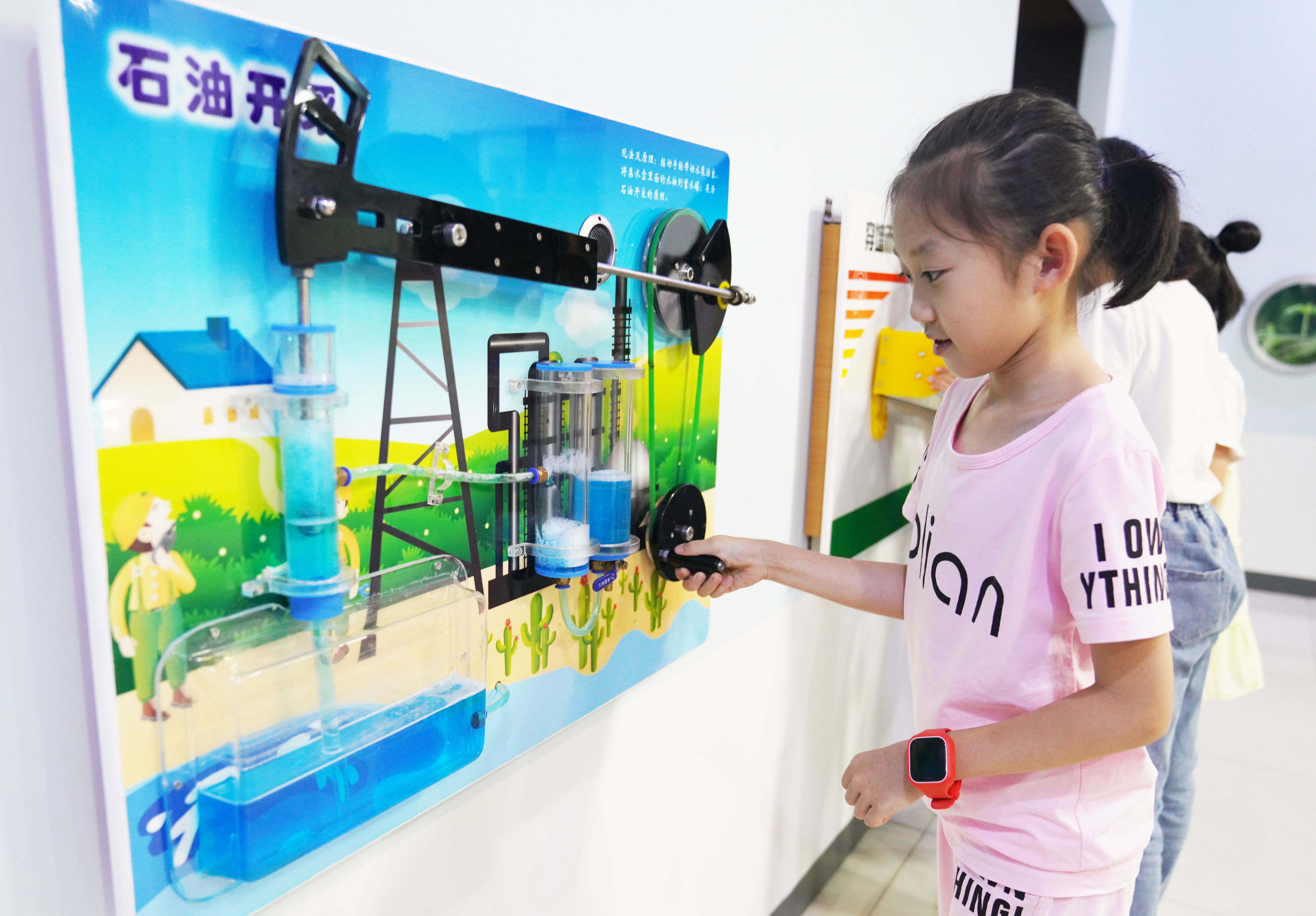 7.7月9日，山东省邹平市妇联、市妇女儿童活动中心举办“情暖童心·牵手共成长”暑期公益训练营，一小朋友在科学实验室通过模型了解石油开采的原理。.JPG