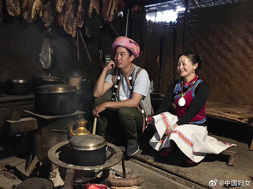 独龙族女主人与怒族男主人在火塘边守护着民族示范家庭